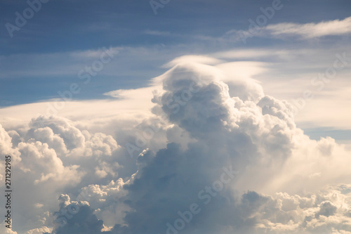 Blue sky with fluffy clouds; soft cumulus and cirrus clouds in the sky. Skyscraper background view seen from the plane.