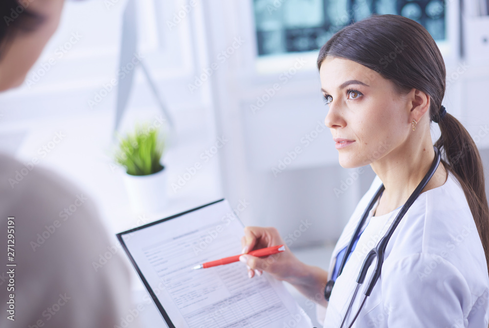 Beautiful female doctor explaining medical treatment to a patient Beautiful female doctor explaining medical treatment to a patient