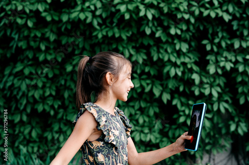 Young girl using a tablet in the street