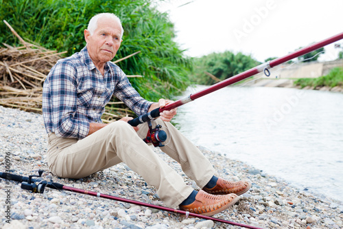 Aged man fishing at lakeside