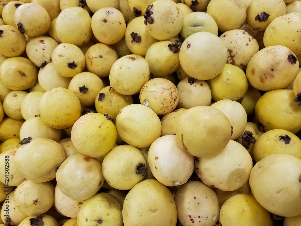 Heap of delicious yellow guavas on the shelf of a supermarket or grocery store. Typical tropical fruit in Latin America. Heap of delicious yellow guavas on the shelf of a supermarket or grocery store. Typical tropical fruit in Latin America.