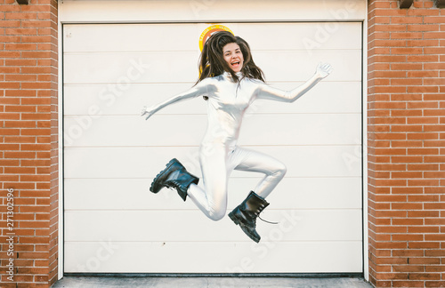 Girl in a silver suit and astronaut helmet jumping