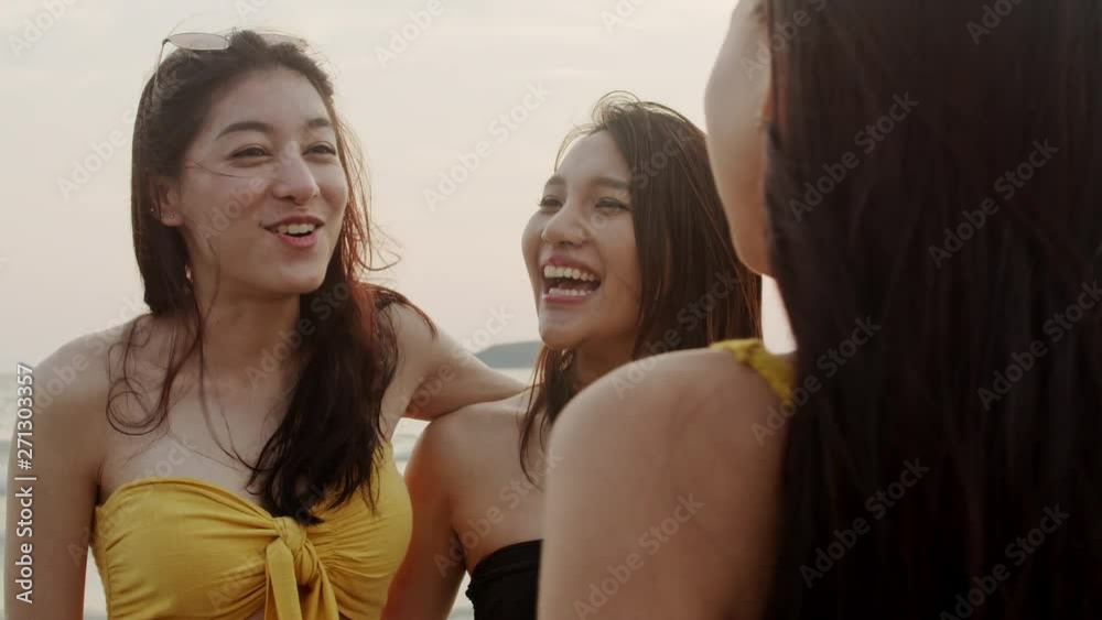Group of Asian women talking together enjoy funny moment on beach, Beautiful female relax on beach near sea when sunset in evening. Woman travel on beach in summer concept. Slow motion shot. Group of Asian women talking together enjoy funny moment on beach, Beautiful female relax on beach near sea when sunset in evening. Woman travel on beach in summer concept. Slow motion shot.