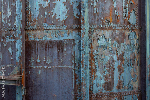 Creative industrial background with rusty metal, rivets, and peeling paint patinas, horizontal aspect