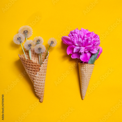 waffle cone with a big pink peony on yellow background. Creative design for pastel wallpaper.