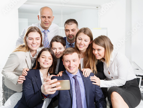 Cheerful business partners taking selfie in coworking space