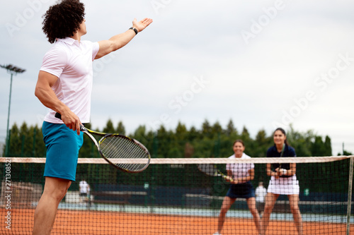 Fit happy poeple playing tennis together. Sport concept © NDABCREATIVITY