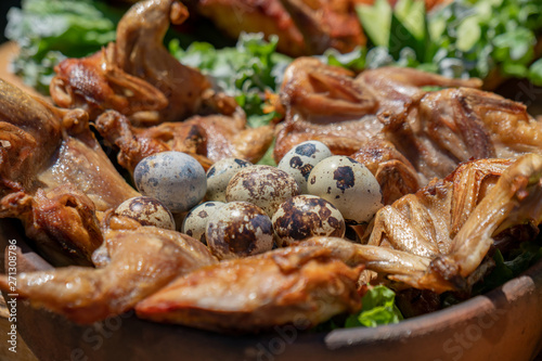 Traditional georgian food grilled chicken Tabaca with Quail eggs and fresh vegetables.