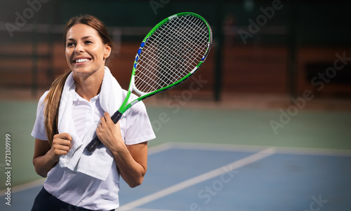Woman tennis player smiling while holding the racket during tennis match © NDABCREATIVITY