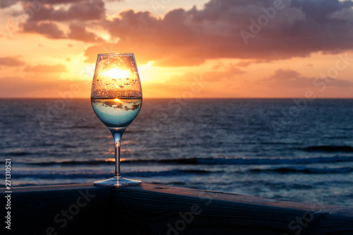 Weinglas vor dem Sonnenuntergang am Meer