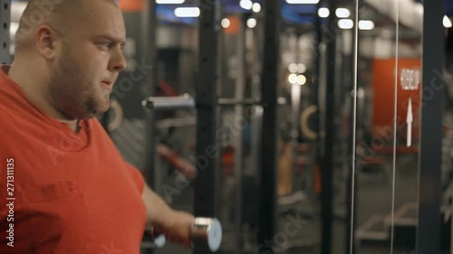 Man using dumbbell in hands and workout in gym