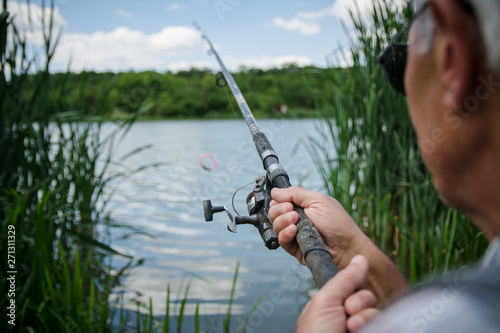 Man throws bait. Fisherman with fishing rod