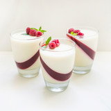 Delicious italian dessert panna cotta with berry sauce, fresh berries and mint on white background. 