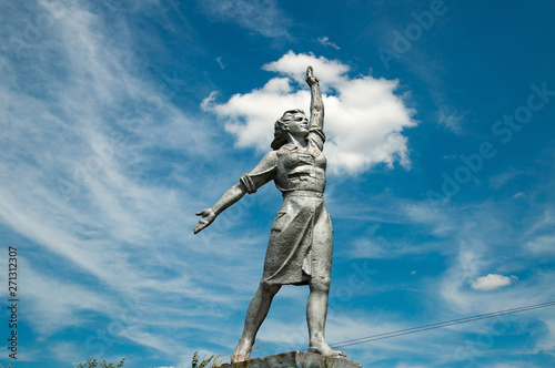 Proud woman historical monument on blue sky with white clouds background. Social realism sculpture in Odessa countryside of Ukraine. Monumental Sculptures of Social-Realism. Soviet woman statue.
