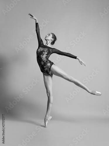 Beautiful ballerina in pointe shoes and colorful clothes posing. Black and white photo.