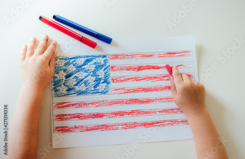 The child draws the flag of America.