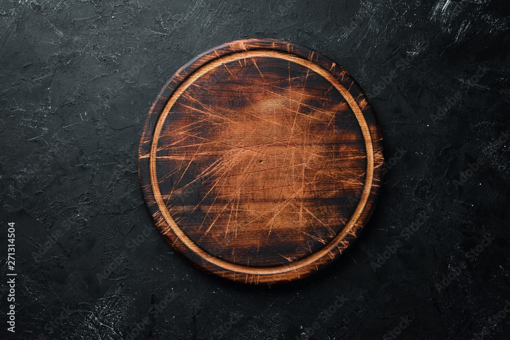 Old Wooden kitchen board on a black background. Top view. Free space for your text. - obrazy, fototapety, plakaty 