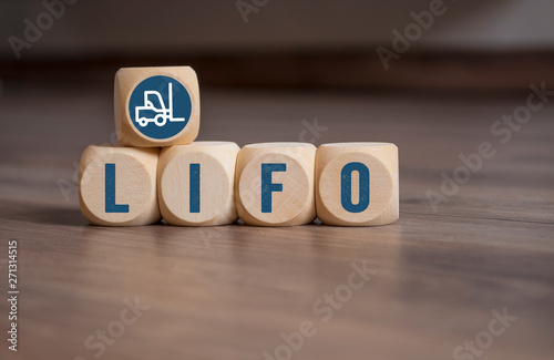 Cubes and dice with LIFO and FIFO accounting on wooden background