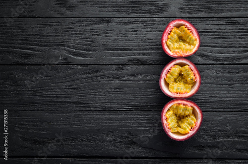 Passion fruits on a wooden background. Tropical Fruits. Top view. Free space for text.