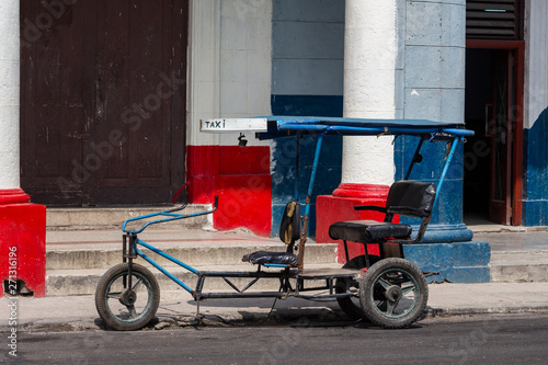 Old tricycle taxi parked on the street of Old Havana, Cuba. Cuban lifestyle.