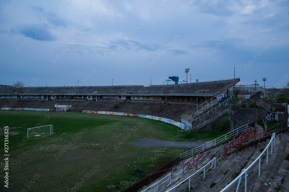 Abadoned Stadion Za Luzankami is a currently inactive stadium in Brno, Czech Republic. Captured in spring sunset, sky and clouds was colored to blue dark colors. Photo from tribunes and inside middle Abadoned Stadion Za Luzankami is a currently inactive stadium in Brno, Czech Republic. Captured in spring sunset, sky and clouds was colored to blue dark colors. Photo from tribunes and inside middle