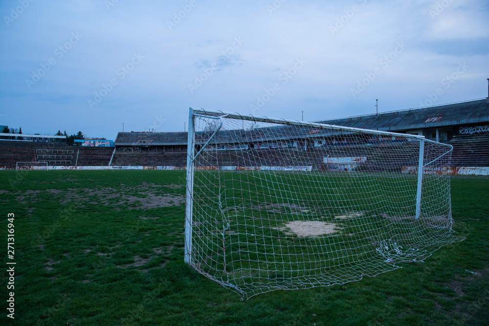 Fototapeta premium Abadoned Stadion Za Luzankami is a currently inactive stadium in Brno, Czech Republic. Captured in spring sunset, sky and clouds was colored to blue dark colors. Photo from tribunes and inside middle
