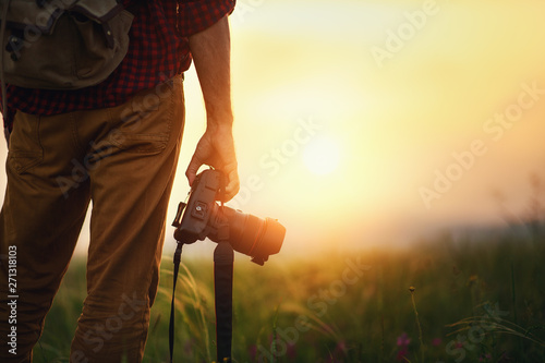 travel photographer. man traveler with camera  at sunset in nature photo