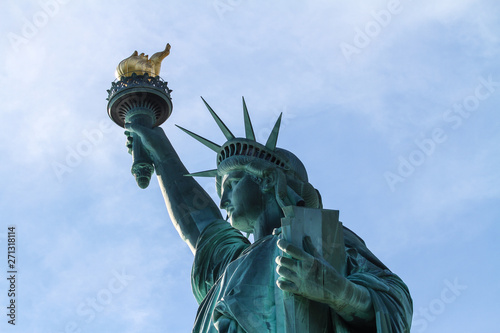 statue of liberty in new york with torch and tablet - close up from side with blue sky photo