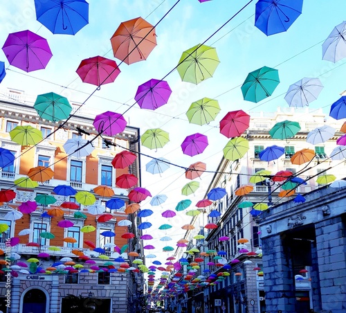 Genova, Italy - 06/01/2019: Bright abstract background of jumble of rainbow colored umbrellas over the city celebrating gay pride photo