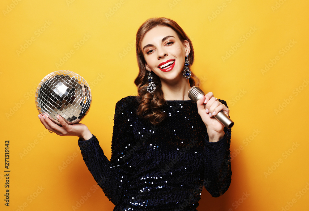 lifestyle, party and people concept - woman in evening dress holding microphone and disco ball lifestyle, party and people concept - woman in evening dress holding microphone and disco ball
