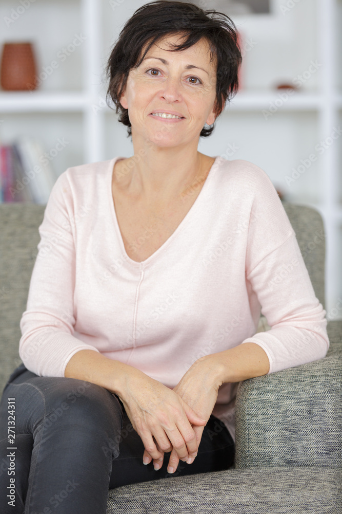Fototapeta premium portrait of woman sitting near white sofa