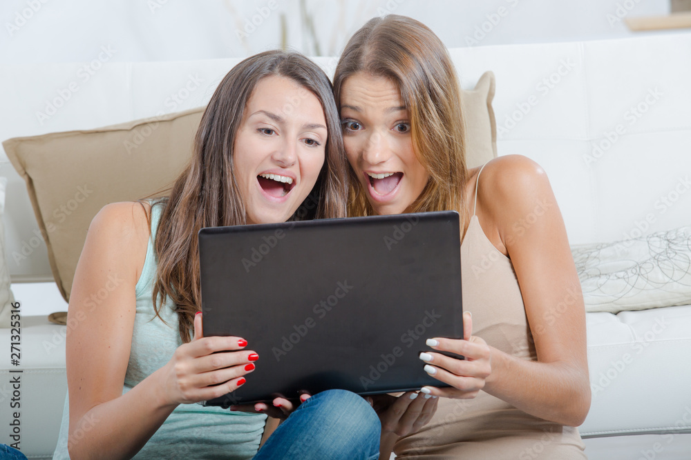 two girls smiling in front of the laptop two girls smiling in front of the laptop