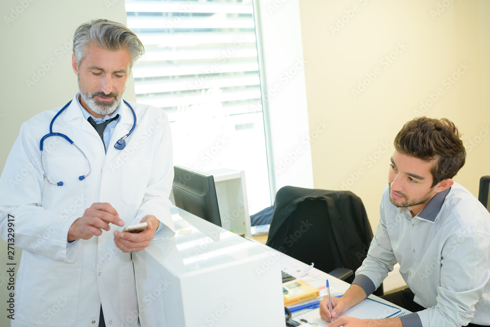 smiling confident doctor at the reception desk smiling confident doctor at the reception desk