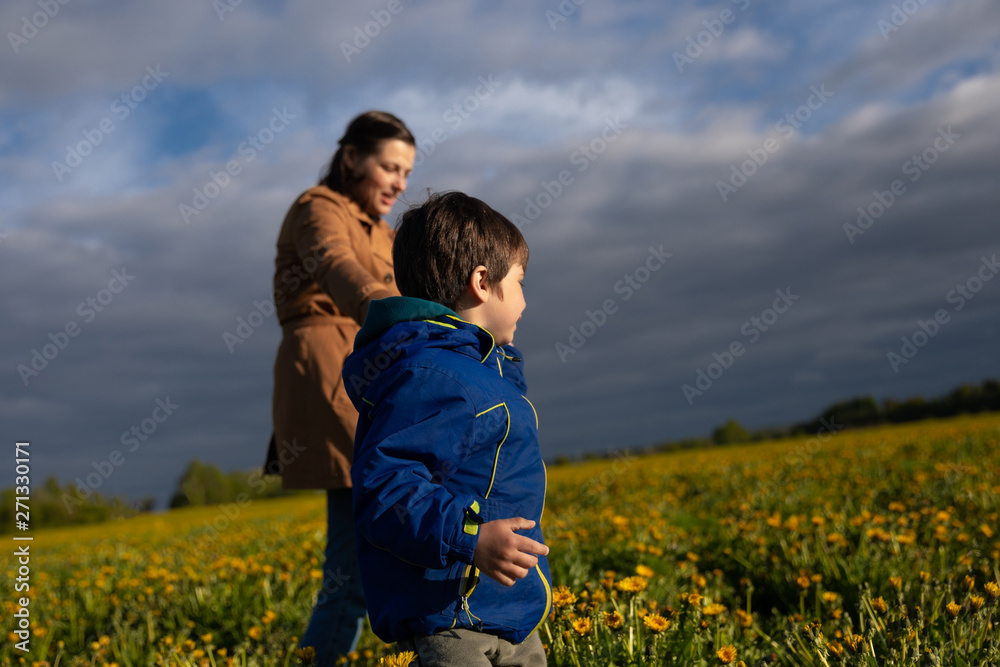 mother walking with her little son on the field. mother walking with her little son on the field.
