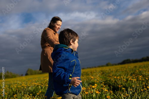 mother walking with her little son on the field.