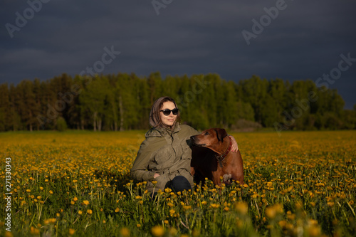 woman walking with a dog in the forest. Rhodesian Ridgeback in the field