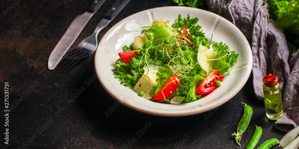 salad vegetable - tomato, lettuce, cheese, microgreen and salad dressing. food background. top salad vegetable - tomato, lettuce, cheese, microgreen and salad dressing. food background. top