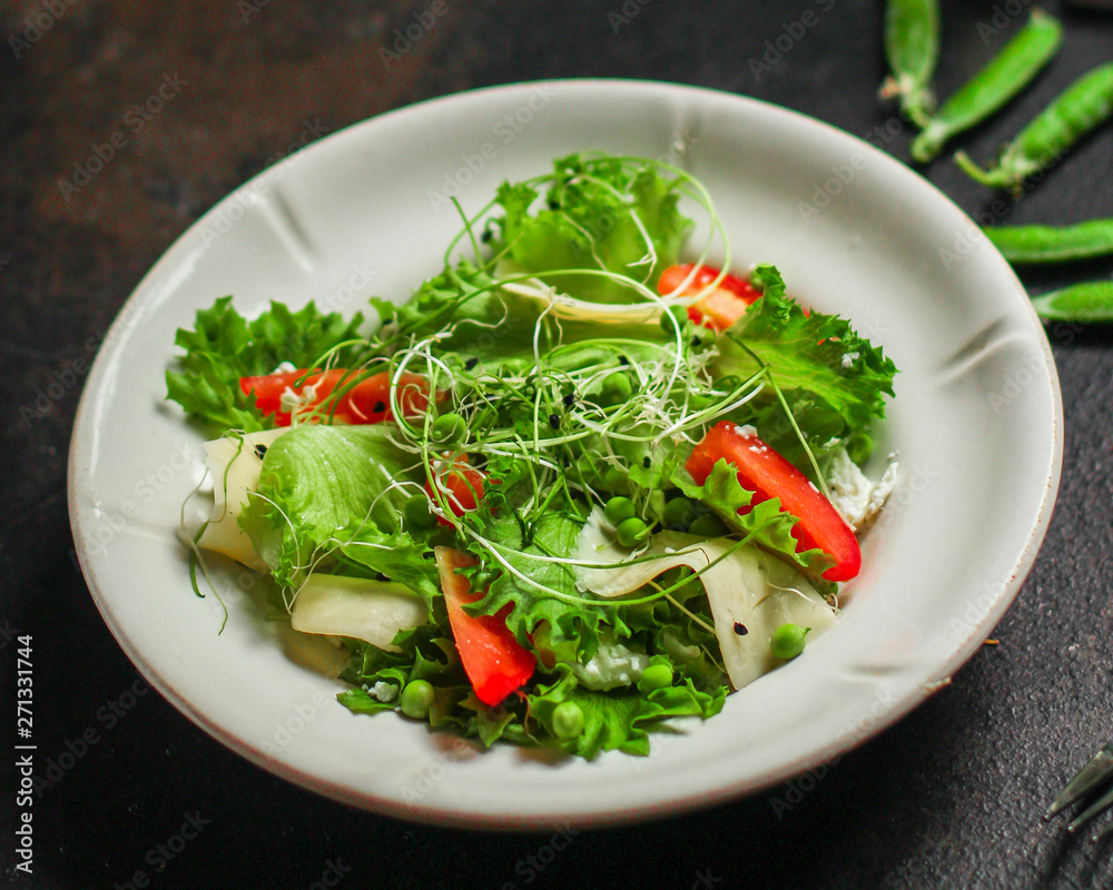 salad vegetable - tomato, lettuce, cheese, microgreen and salad dressing. food background. top salad vegetable - tomato, lettuce, cheese, microgreen and salad dressing. food background. top