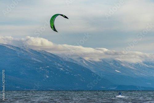 Kite surfer on lake with mountains