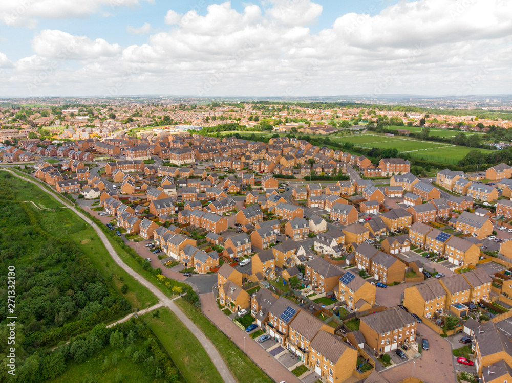 Aerial photo over looking the area of Leeds known as Beeston in West Yorkshire, showing the newly built housing estate taken on a sunny part cloudy day.