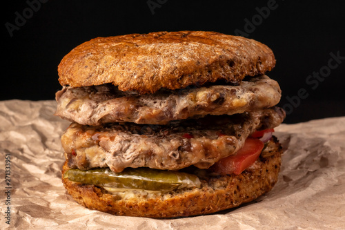 Powerful juicy burger with two chops and vegetables