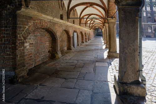 Fototapeta Naklejka Na Ścianę i Meble -  Arcade passage in the backyard of St. Mary's Cathedral (german Marienkirche) and the town hall in the historic old town of Luebeck, a popular tourist destination in northern Germany
