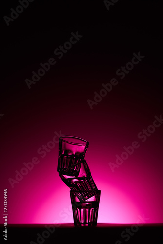 pyramid of glasses on dark background with pink illumination © LIGHTFIELD STUDIOS