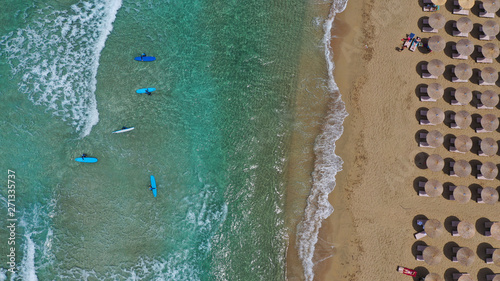 Aerial drone top view photo of young team of surfers enjoying tropical wavy turquoise sea sandy beach in exotic caribbean island