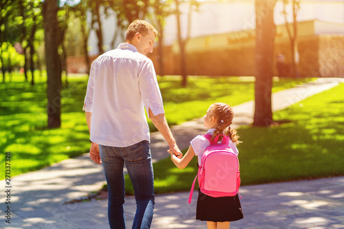 father leads daughter to school in first grade. first day at school. back to school.