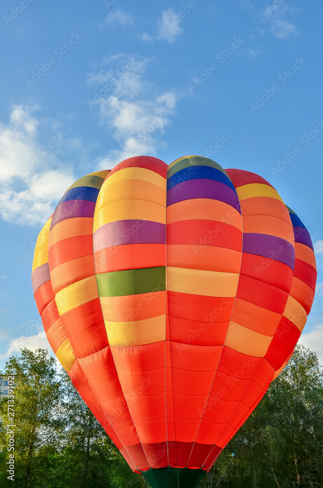 Naklejka premium Colorful hot air balloon heading up in blue sky. Close up.