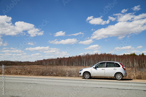 Car on asphalt road in early spring near forest and blue sky with clouds. Landscape in in nice spring day. Russia © keleny