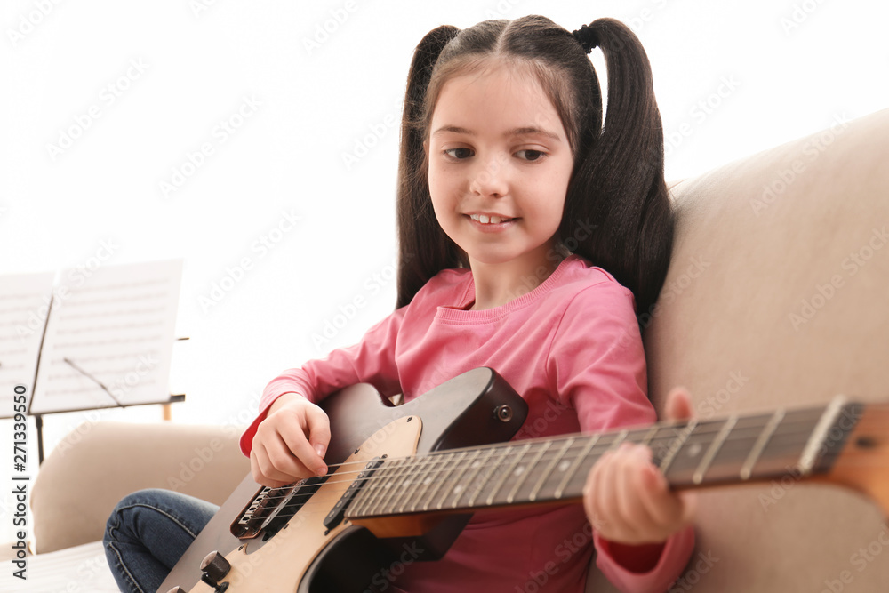 Little girl playing guitar at home. Learning music notes Stock Photo ...