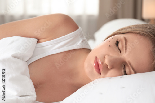 Young woman with eyelash loss problem sleeping in bed