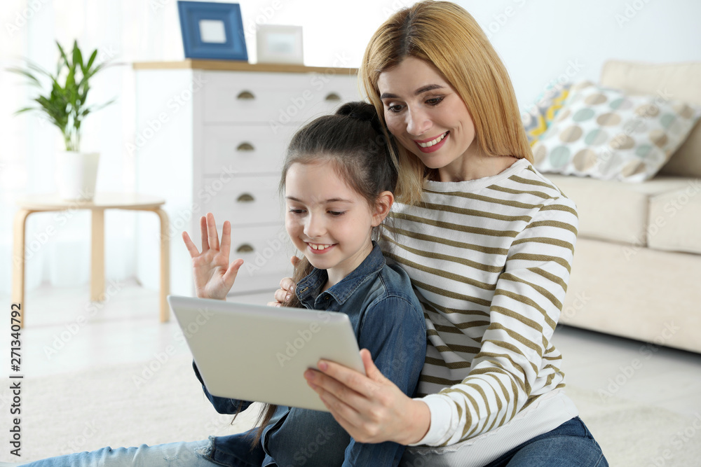 Mother and her daughter using video chat on tablet at home Mother and her daughter using video chat on tablet at home